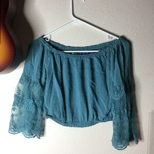 Turquoise off the shoulder top with sheer sleeves.